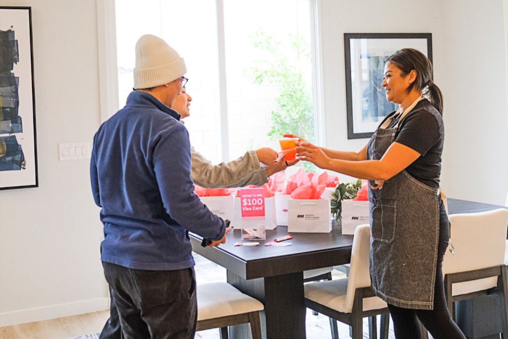 A coffe bar catering barista hands grinks to real estate event guests.