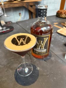 A Kick Off before Superbowl LX a picture of an espresso martini with a W on the middle and a bottle of whisky in the back